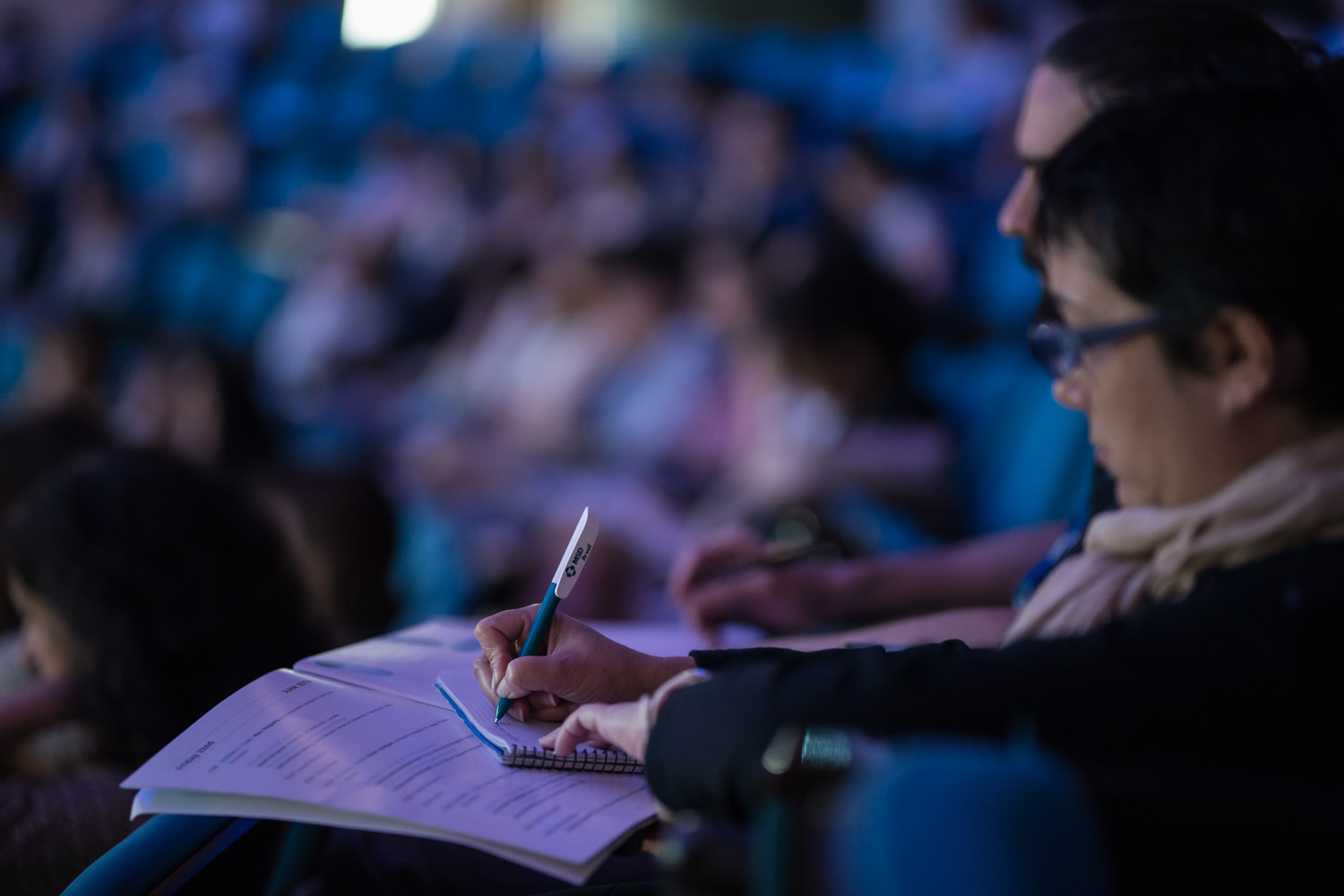 Woman writing at The Barcelona Debates on the Human Microbiome 2018